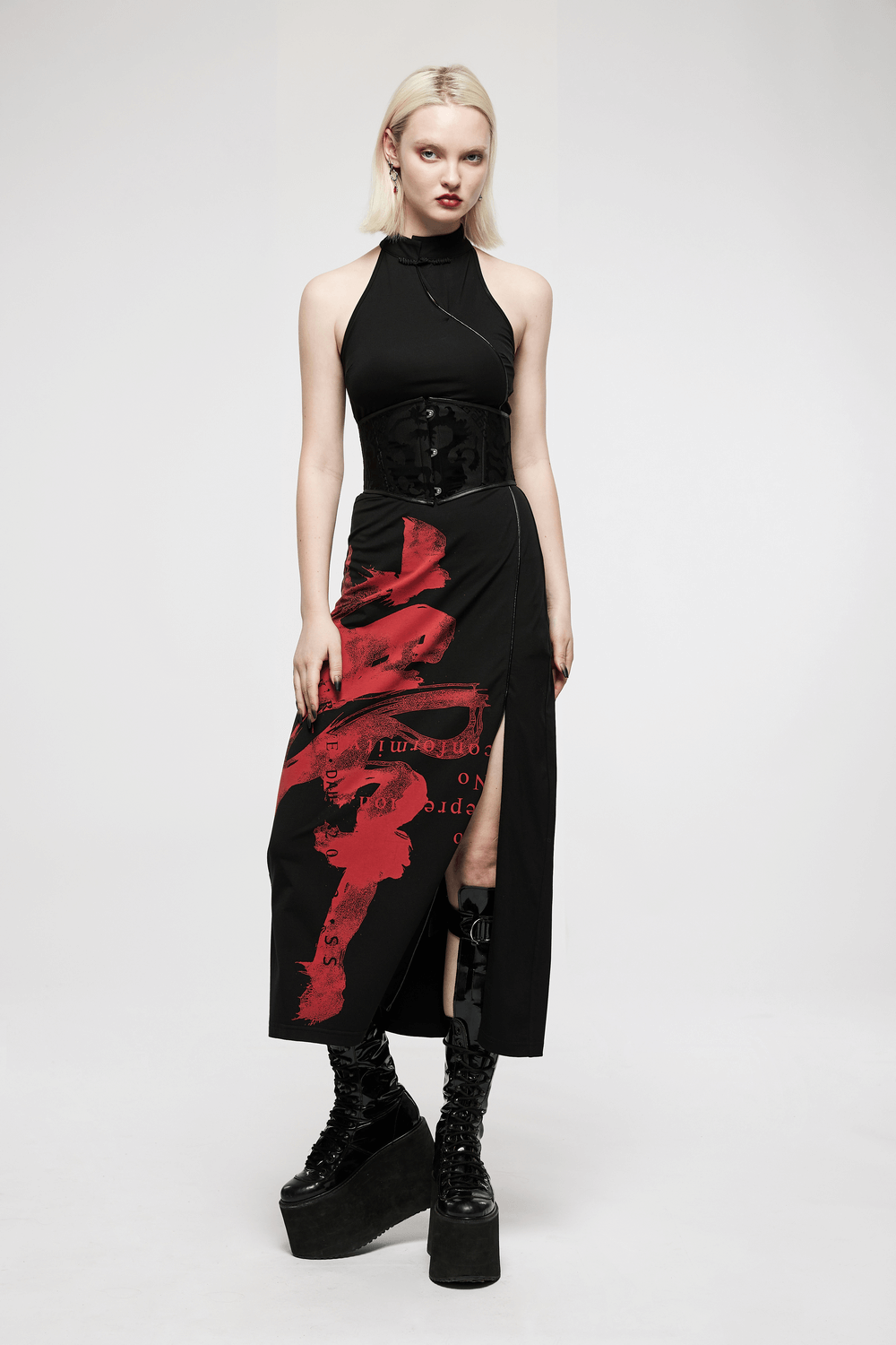 Stylish woman in gothic corset belt and black dress with red print, showcasing elegance and unique style.