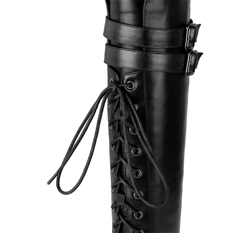Close-up of stylish black leather women's boots featuring lace-up and buckle details, perfect for a goth or rock style.