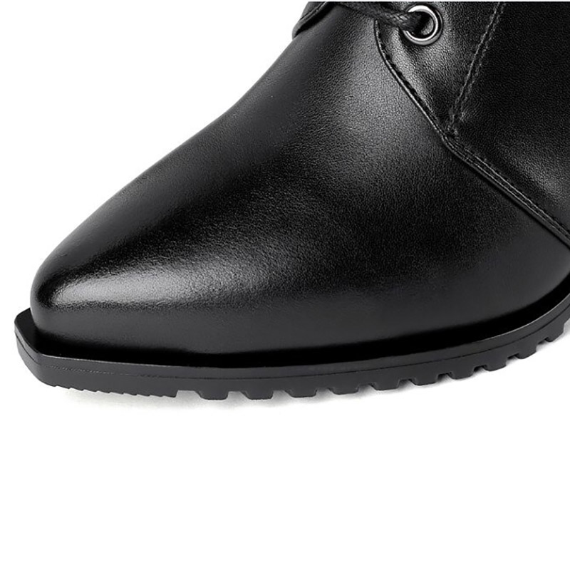 Close-up of stylish black women's genuine leather boots with a pointed toe and durable sole for rock fashion.