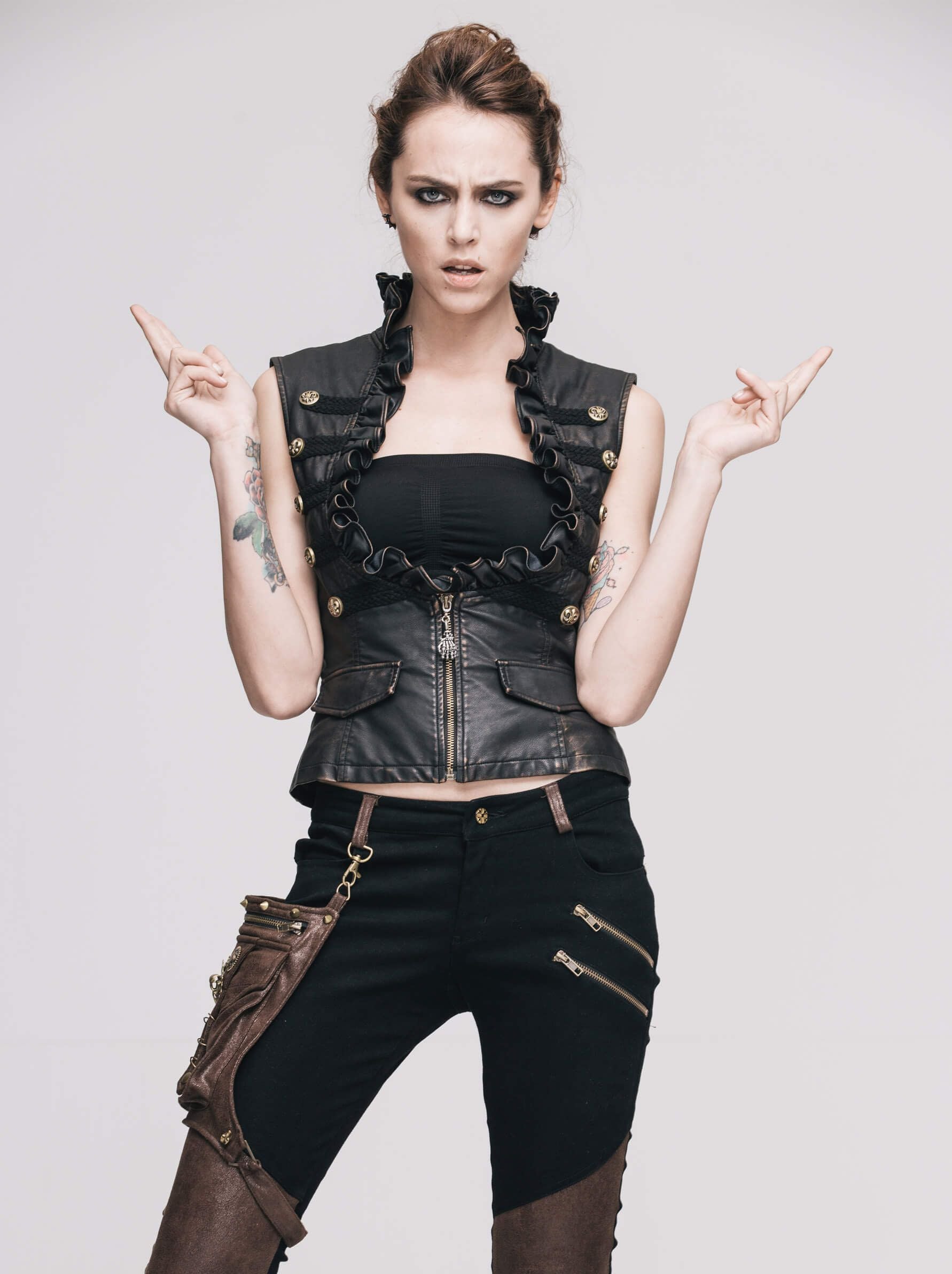 Stylish woman in a black steampunk PU leather waistcoat with frills and gold buttons, showcasing a bold fashion statement.