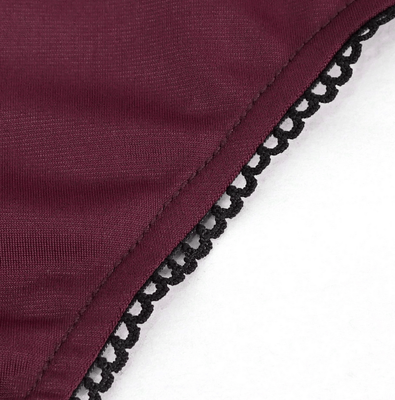 Close-up of wine red fabric with black lace trim, showcasing the stylish detail of a women's gothic swimsuit.