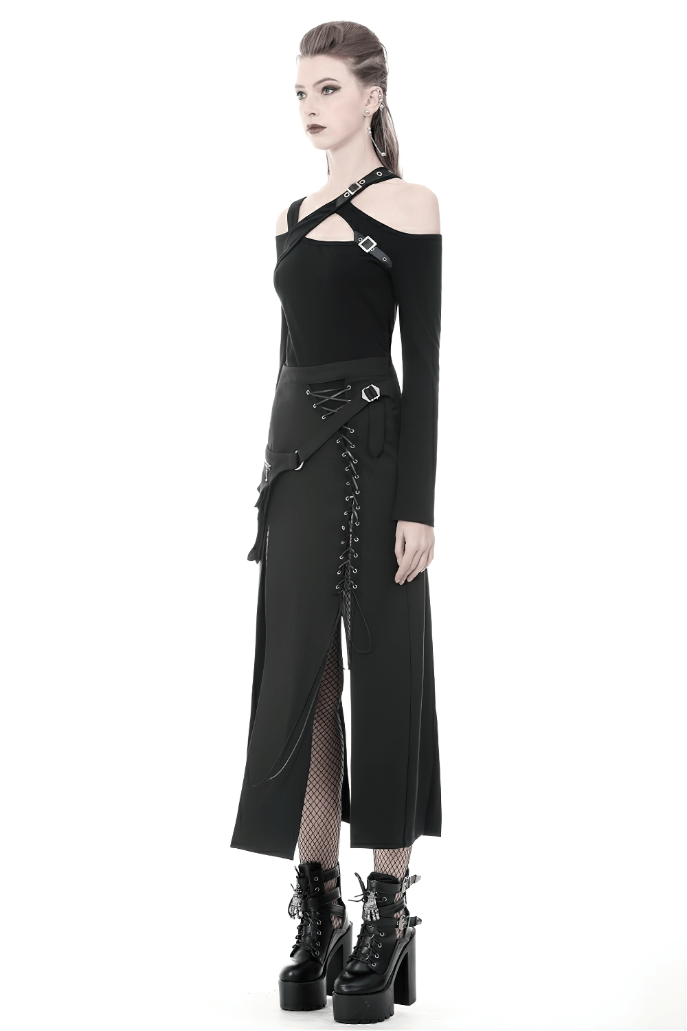 Chic goth model in stylish black lace-up skirt with pockets and asymmetrical hem, paired with edgy strappy top and platform boots.