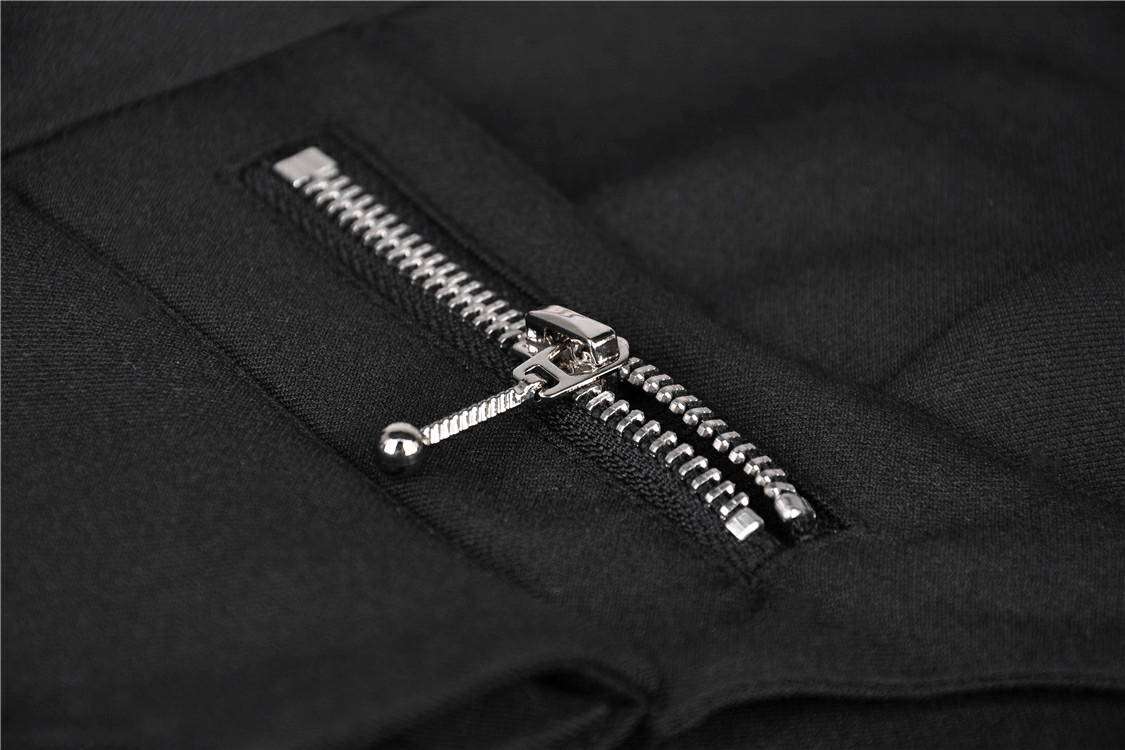 Close-up of stylish metal zipper detail on a black fabric, adding sleek functionality to a gothic-inspired look.