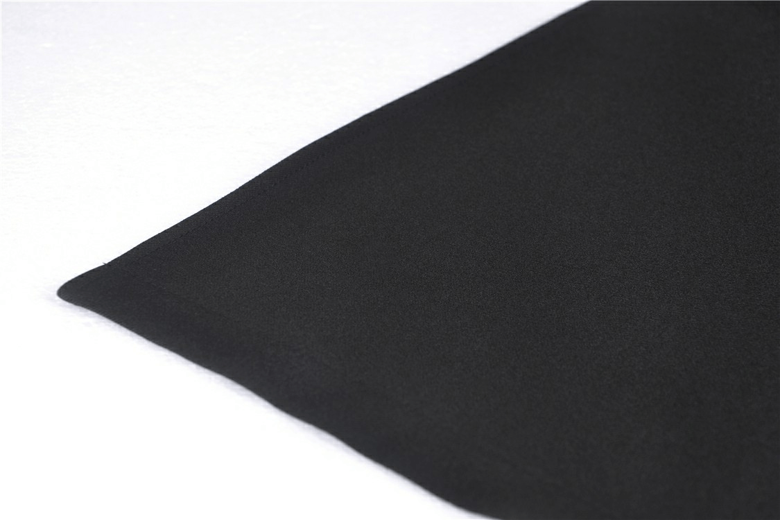 Close-up of the hemline of a black gothic lace-up skirt, showcasing its smooth fabric and stylish design.