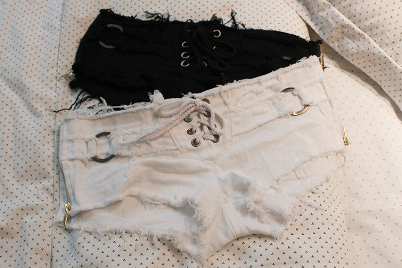 Stylish black and white sexy women's grunge denim shorts with lacing details on a polka dot background.