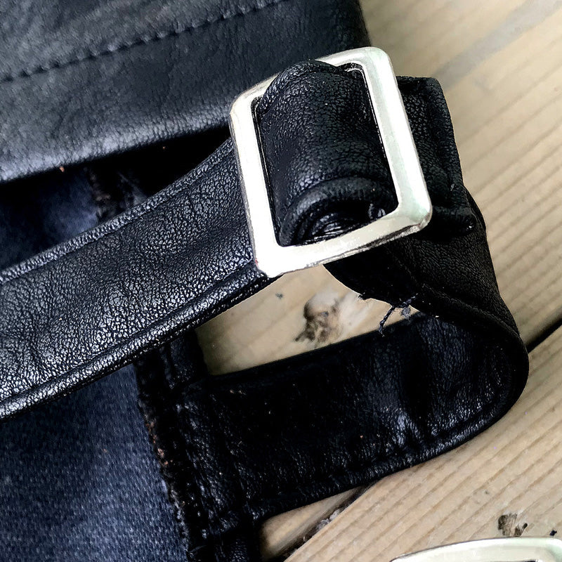 Close-up of black imitation leather strap with silver buckle on high waist shorts, perfect for summer gothic fashion.