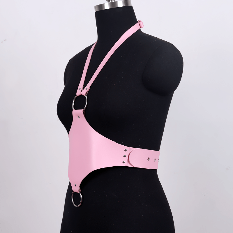 Pink faux leather body harness on mannequin, featuring metal rings and adjustable straps for a stylish gothic look.