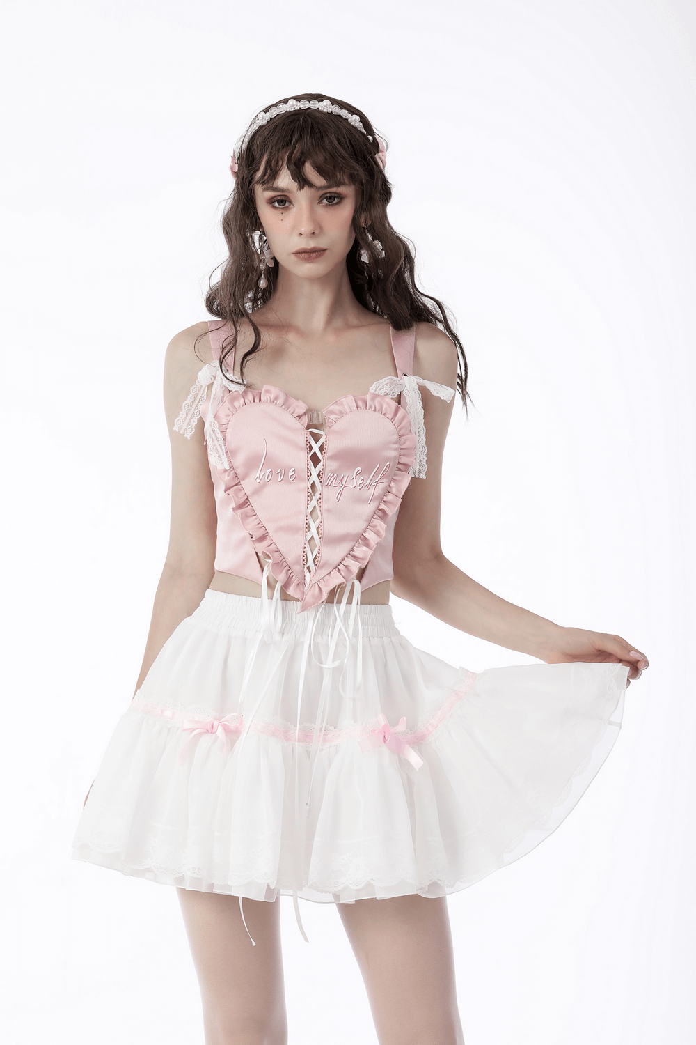 Sweet Lolita style model in pink top and white pleated mini skirt with pink bows, perfect for a kawaii fashion look.