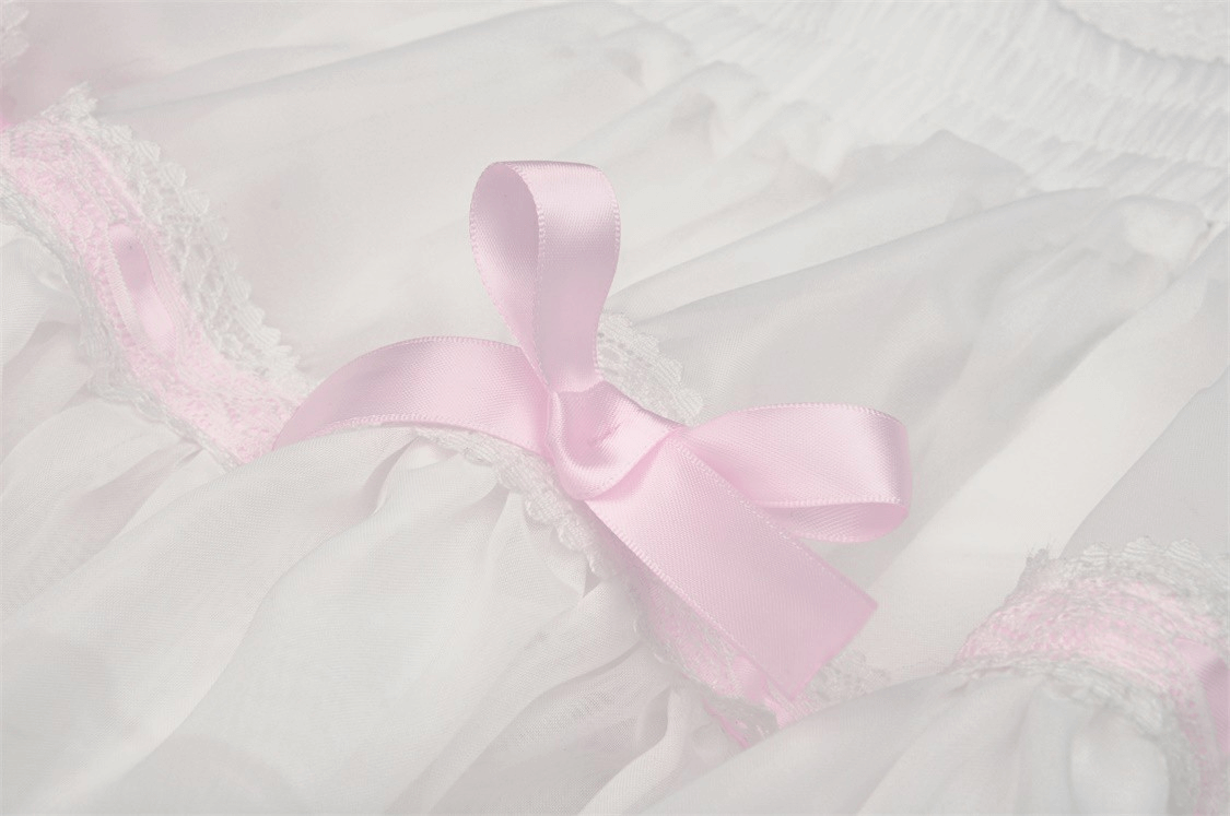 Delicate pink ribbon on white fabric, adding a cute touch to a sweet Lolita outfit.