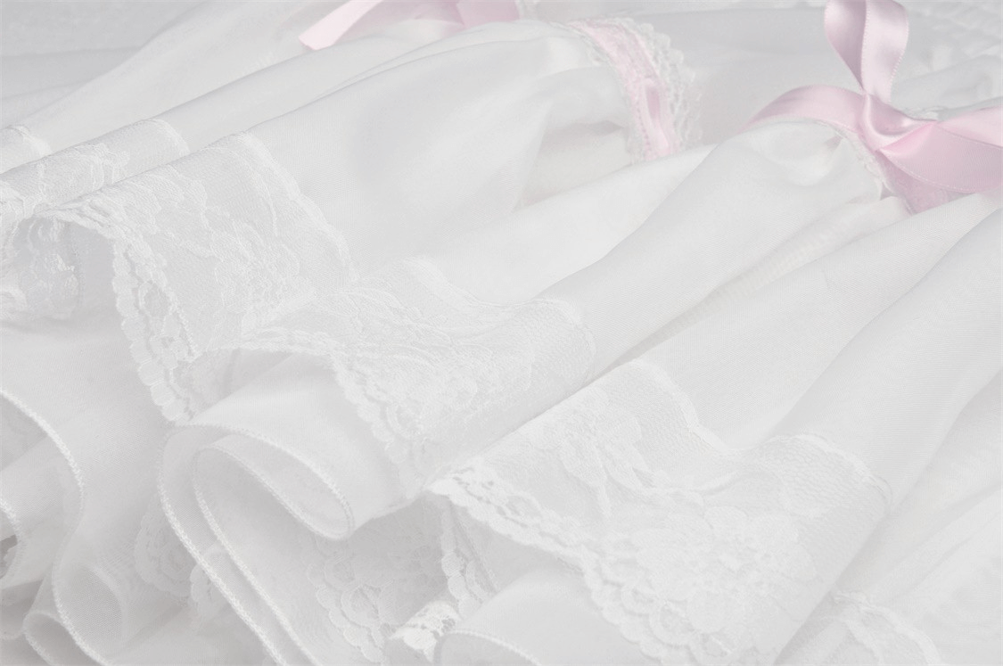 Delicate white fabric with lace and pink ribbons, perfect for a sweet Lolita mini skirt look.