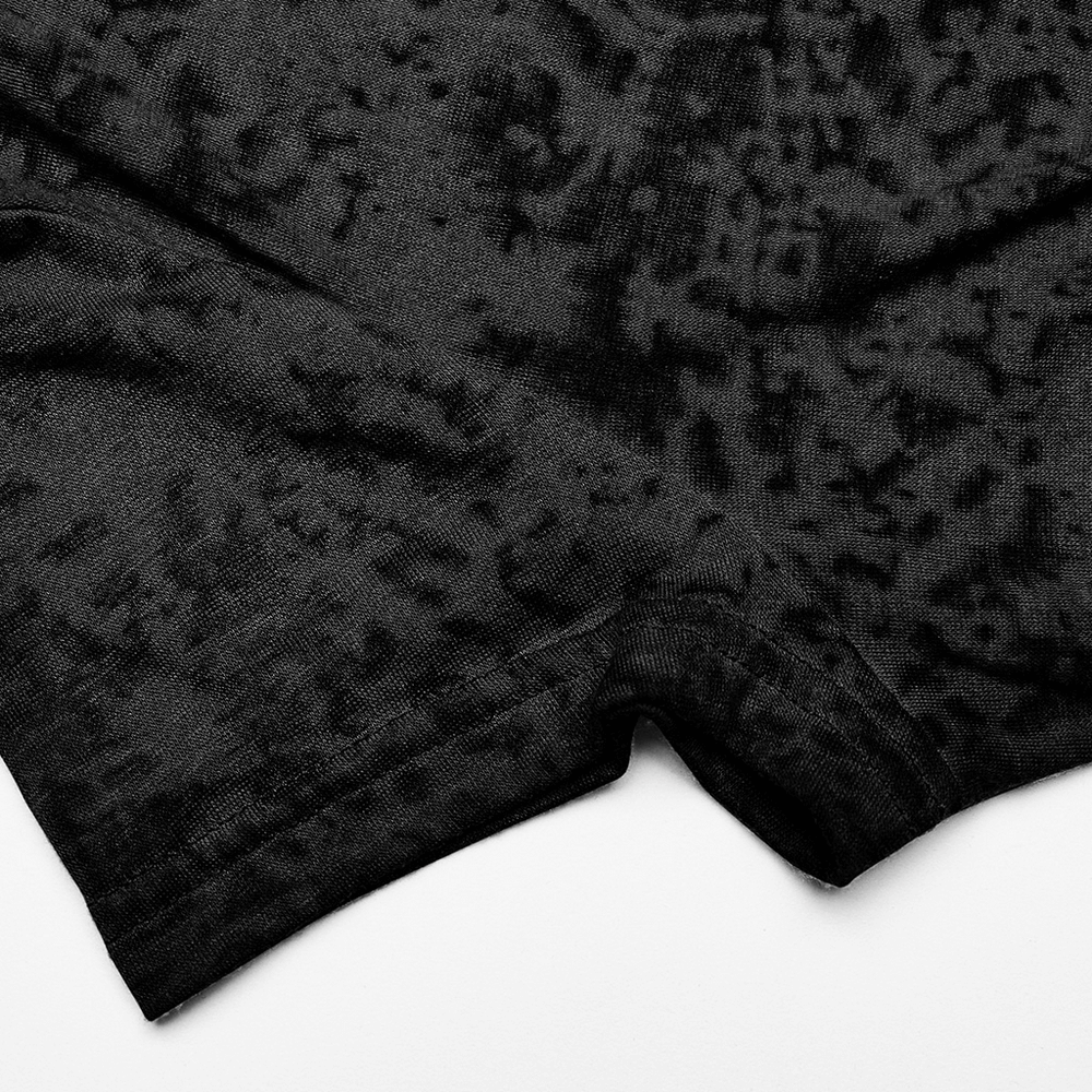 Close-up of the textured hem of a black cropped hooded top, showcasing its unique criss-cross design.