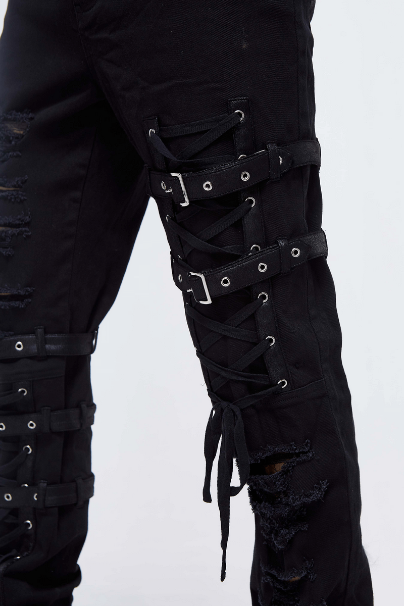 Close-up of men's gothic black skinny jeans with tactical lace holes and ripped details, perfect for steampunk style.