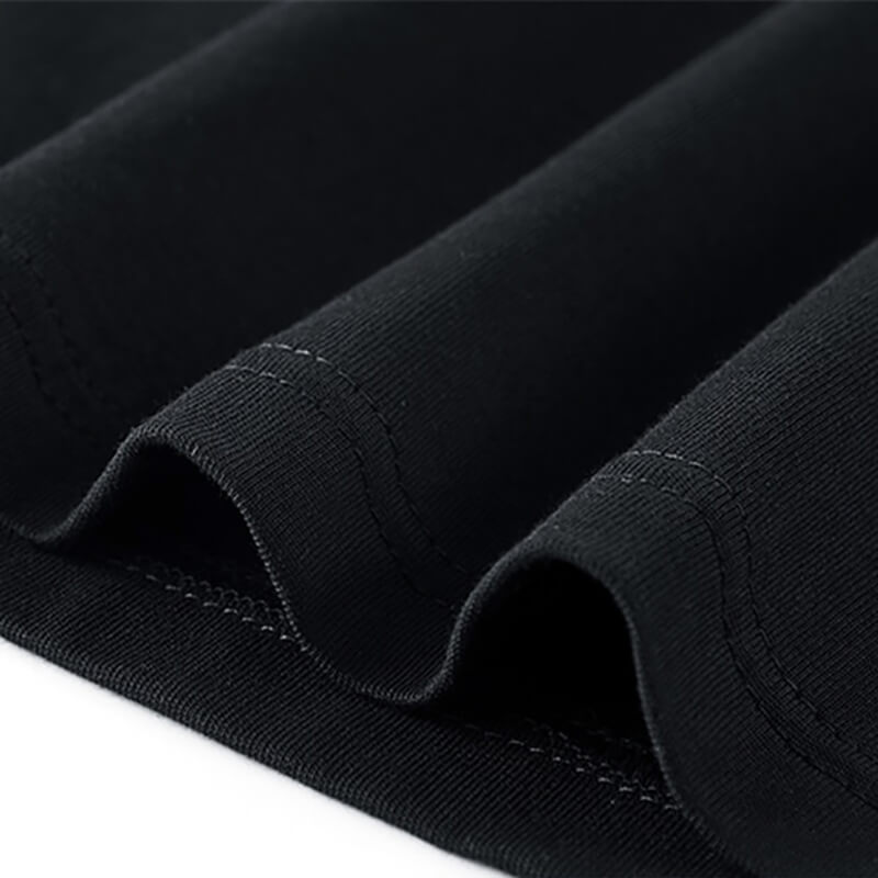 Close-up of the fabric folds and stitching on a black tactical patchwork T-shirt for men.