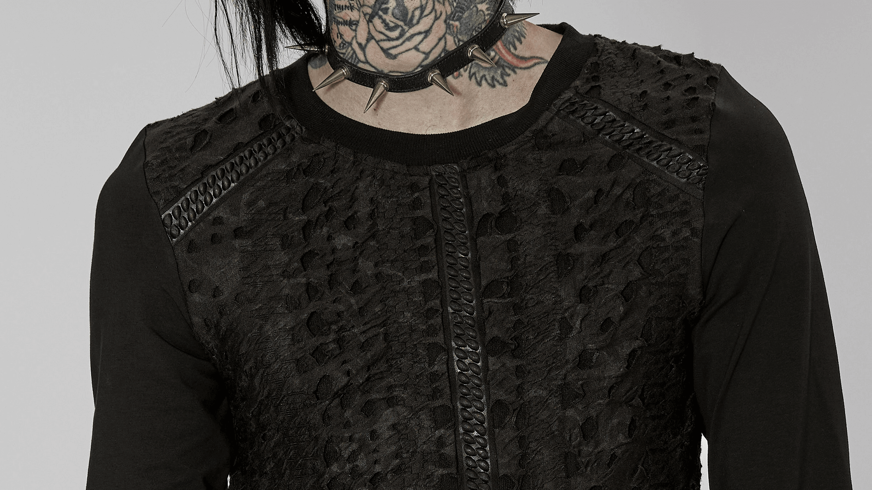 Close-up of a goth-inspired black knit top with textured webbing and long sleeves, showcasing a unique style.