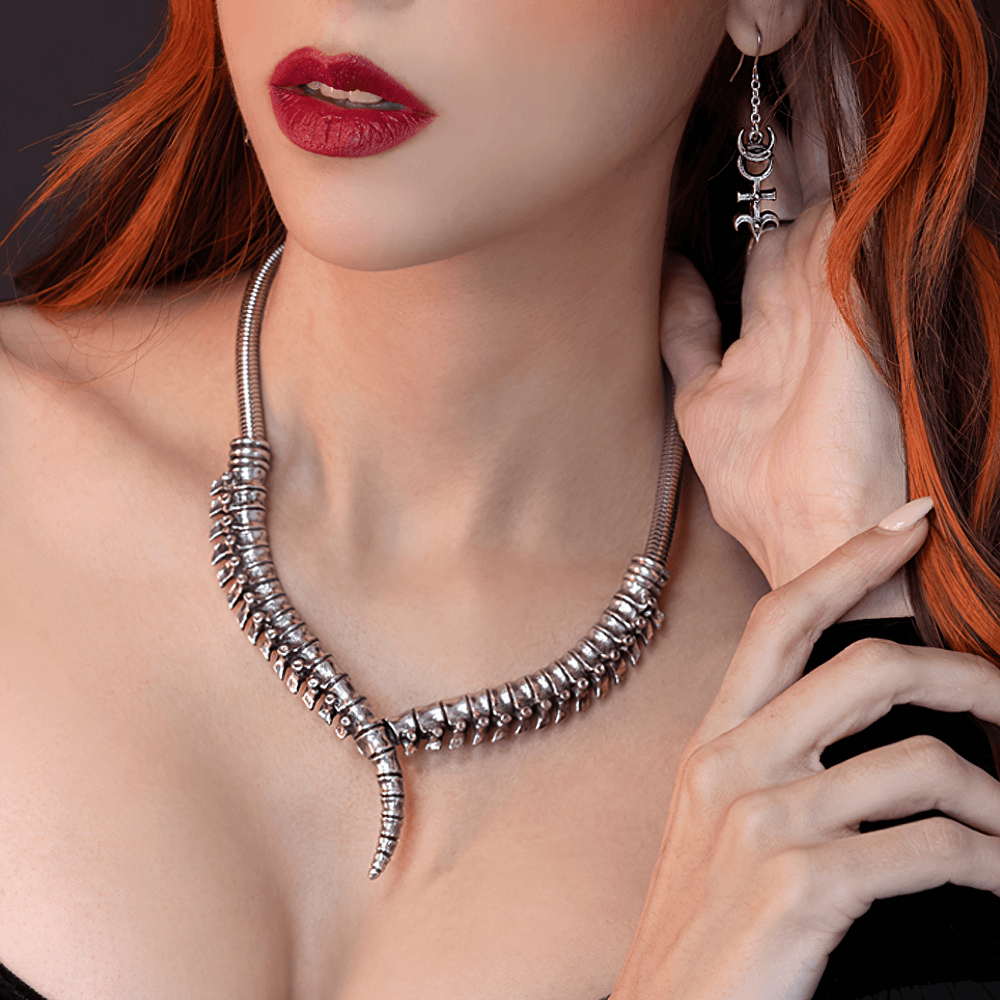 Thoracic Vertebrae-Inspired Spine Collar Necklace worn by a model with striking red lips and matching earrings.