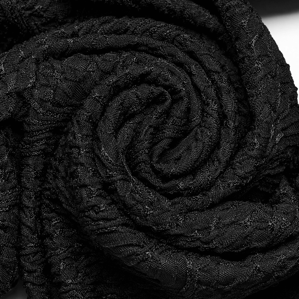 Rolled black lace fabric showcasing a textured pattern, perfect for stylish gothic garments.