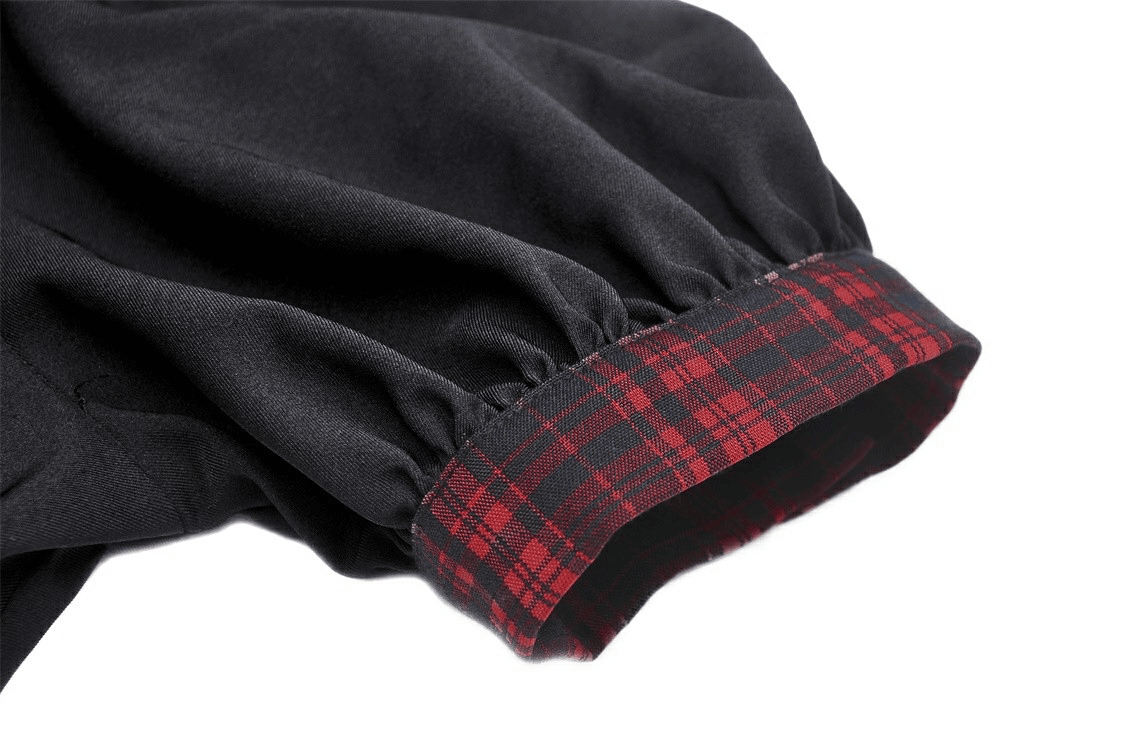Close-up of trendy black dress sleeve with plaid accent and bow detail, showcasing stylish black and red tartan trims.