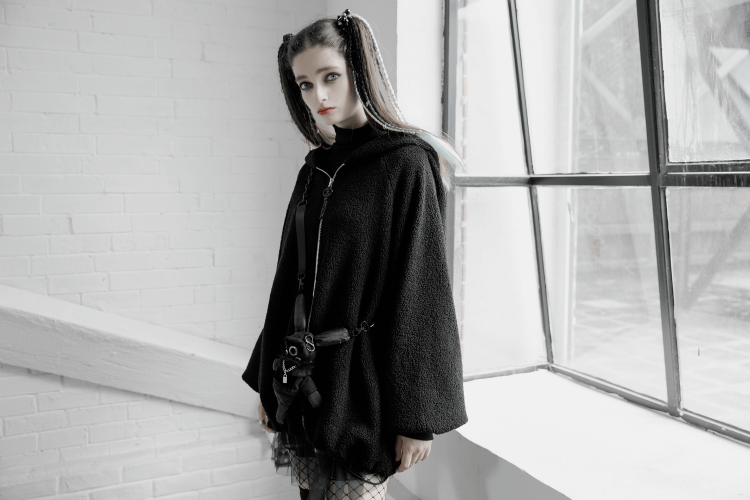 Trendy black hooded jacket with unique clown hat design and rabbit plush purse, perfect for edgy fall fashion.