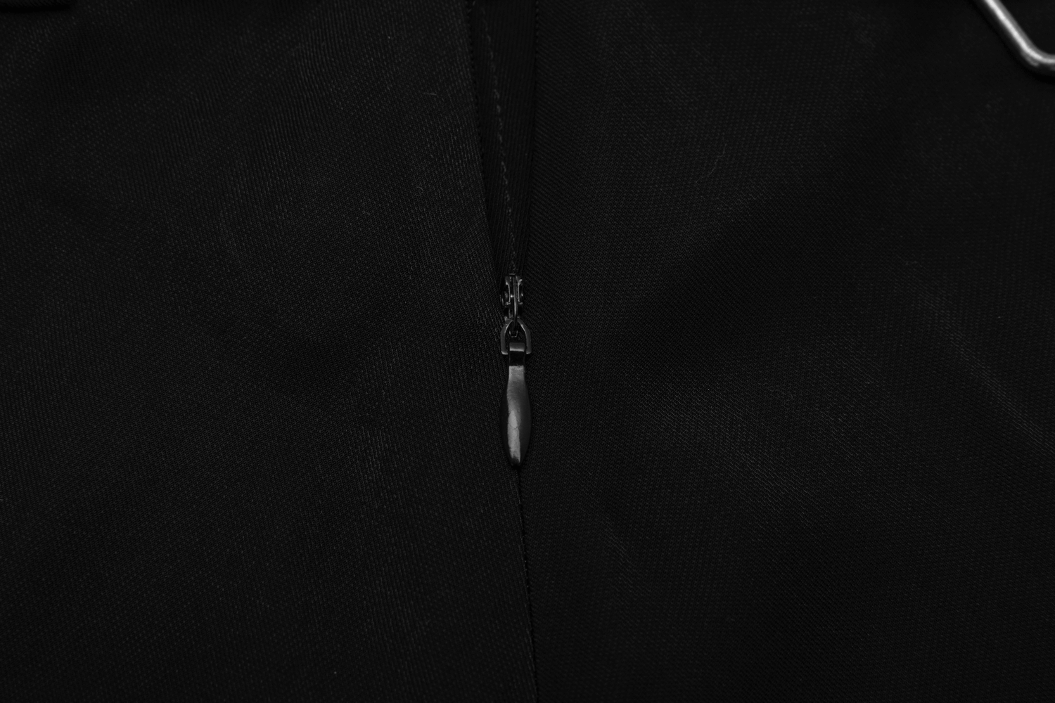 Close-up of the zipper detail on a fashionable black Gothic mini skirt.