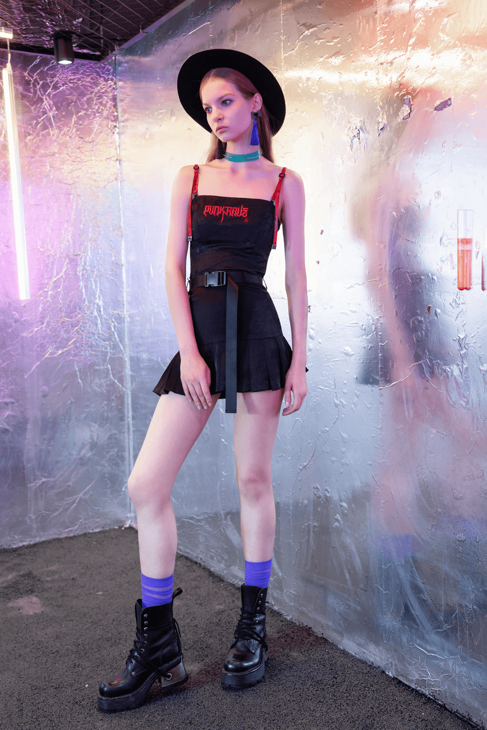 Model showcasing a trendy gothic buckle mini skirt with D-ring detail and utility pouch in a stylish streetwear outfit.