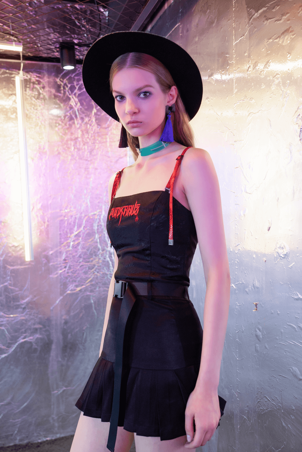 Trendy Gothic buckle mini skirt outfit with pleated design and unique accessories in urban setting.