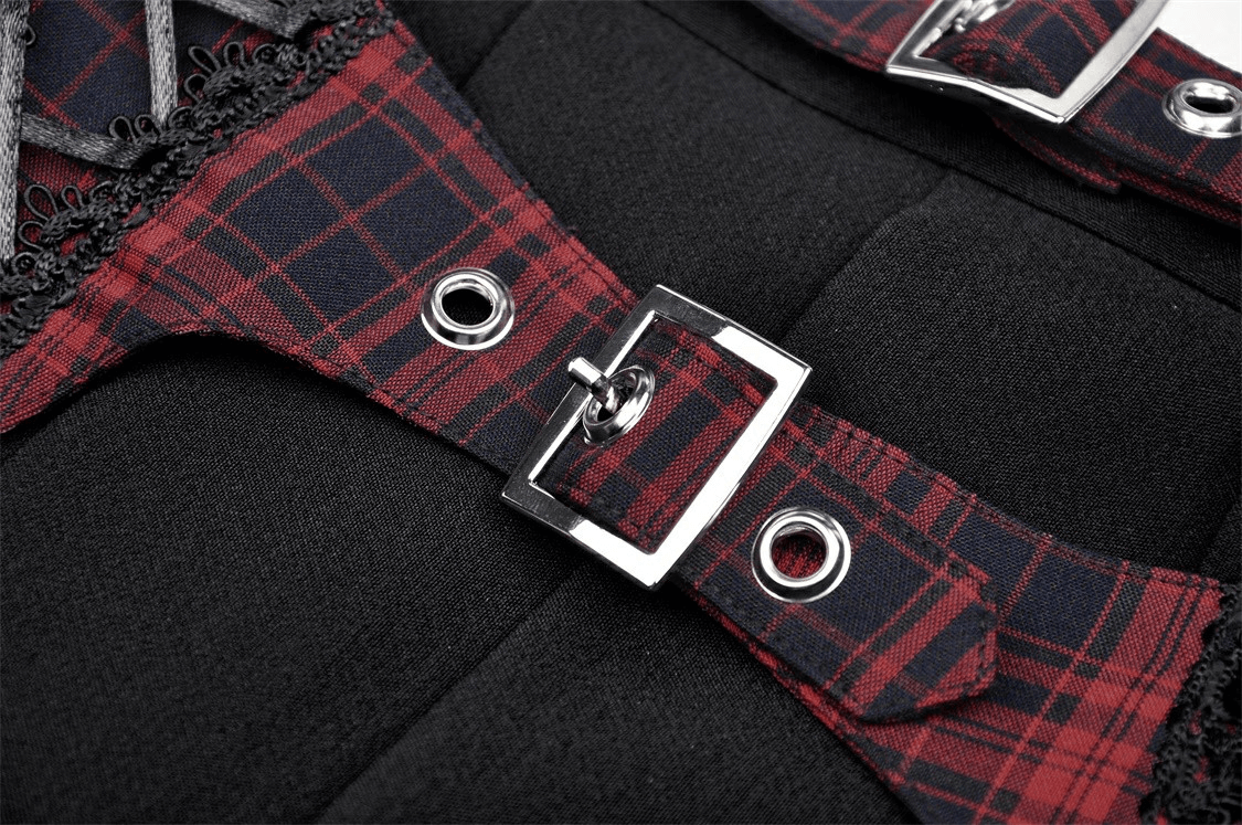 Close-up of trendy plaid and black mini skirt buckles showcasing stylish design and pleated detail.