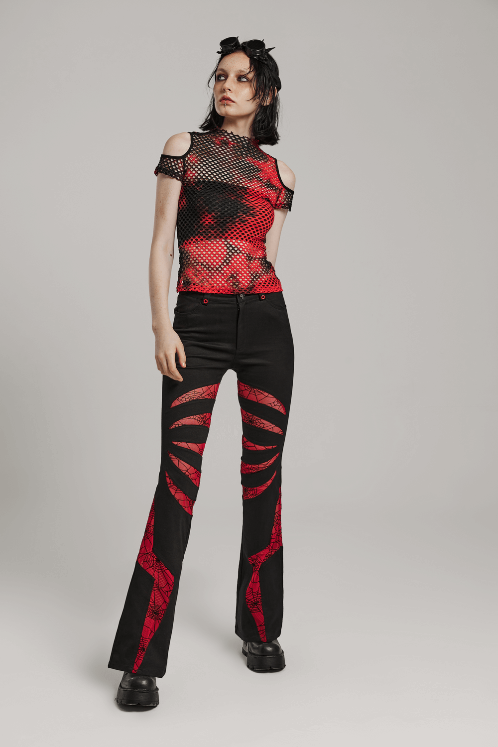 Trendy punk mesh T-shirt in bold tie-dye colors paired with black flared pants, perfect for edgy fashion lovers.