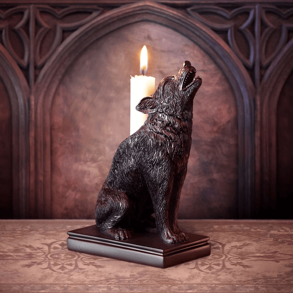 Ulula Noctis Wolf Candle Holder in black resin with a howling wolf design, illuminating a candle.