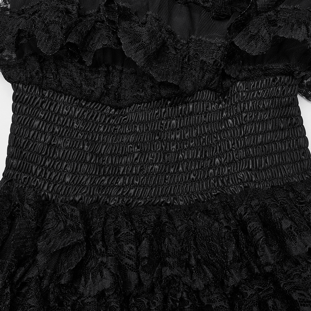 Close-up of the smocked bodice of a women's black lace high-low dress with ruffled detailing.
