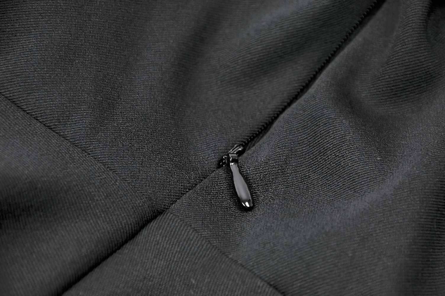 Close-up of the zipper detailing on a unique black and white dress with lace collar and bows.