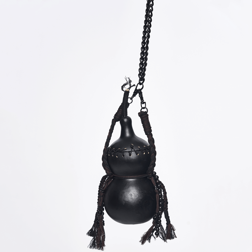 Unique Black Crossbody Mini Bag with Chains and Tassels showcased with braided tassels and metal chains.