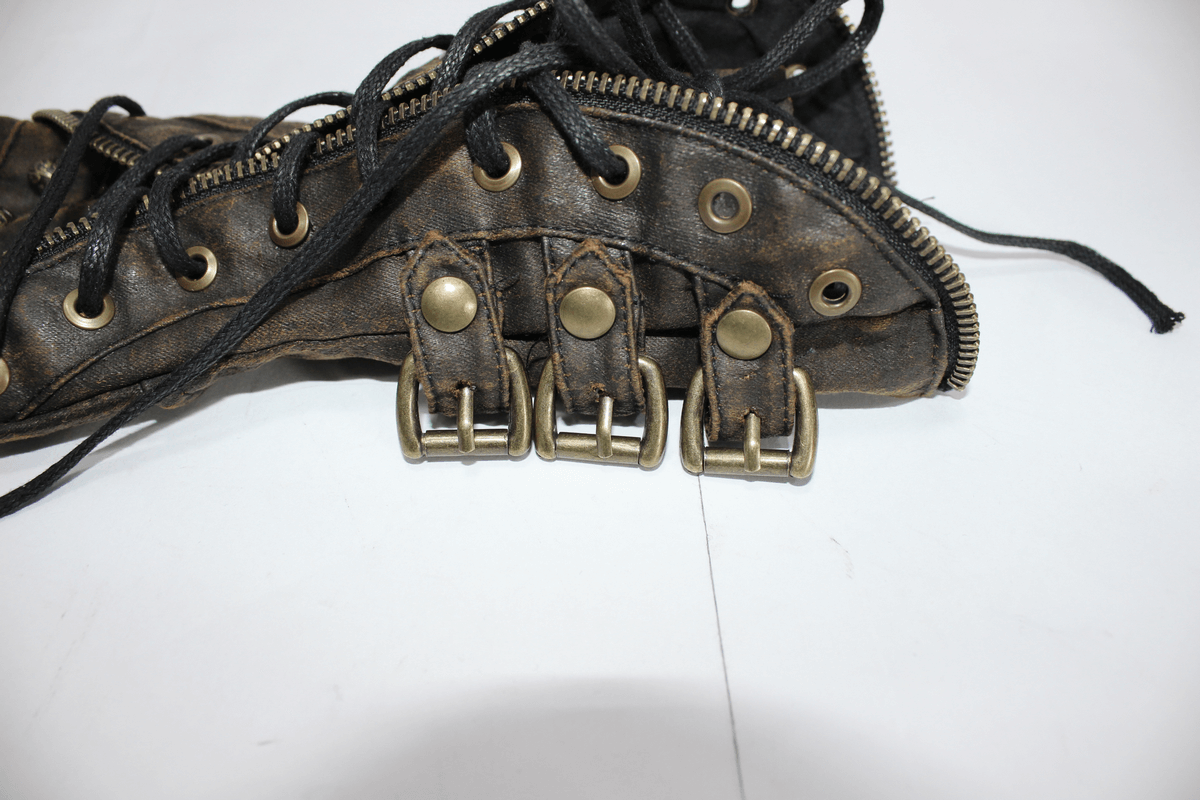 Close-up of vintage brown steampunk fingerless gauntlet gloves featuring buckled straps and lacing details.