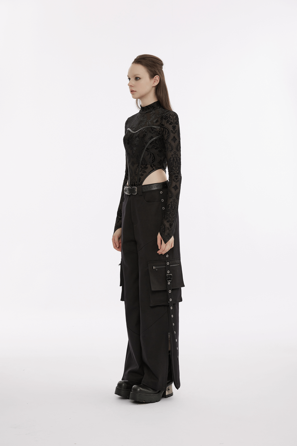Side view of a model wearing urban black cargo pants with pockets and a stylish long-sleeve top.