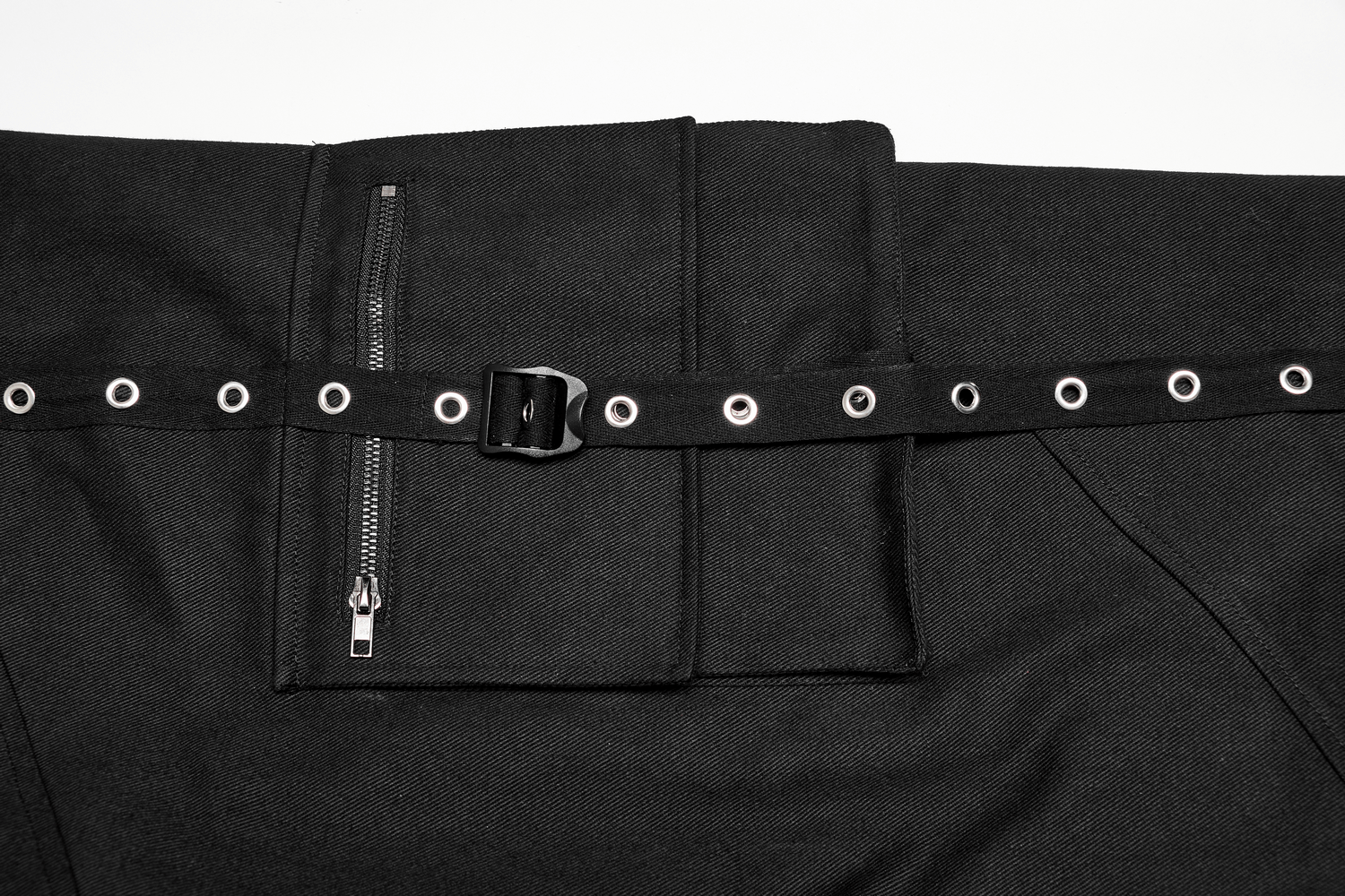 Close-up of urban black medium waist cargo pants with eyelet webbing and metallic zipper accents.