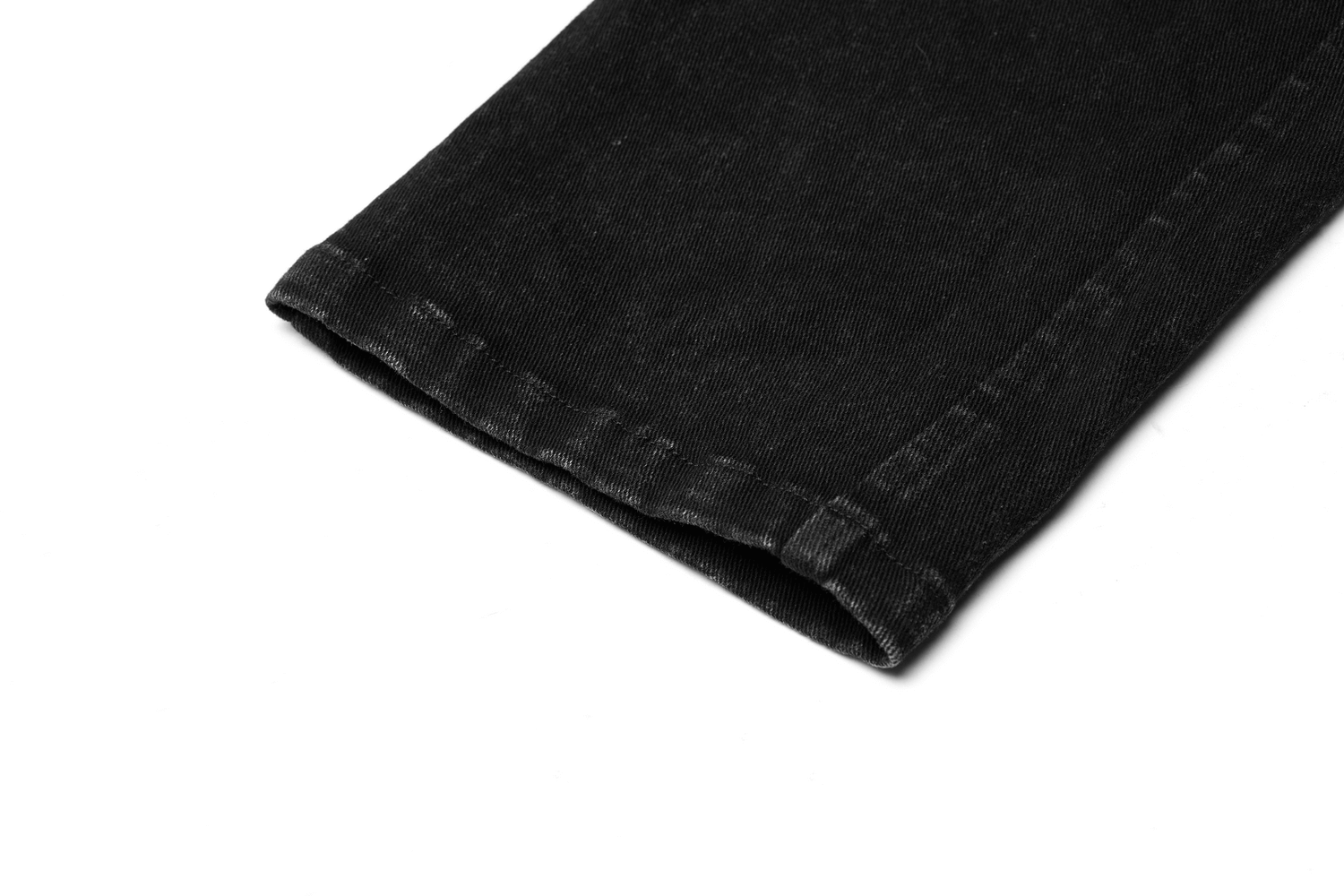 Close-up of black strap-detailed cargo trousers hem showcasing elastic woven fabric and meticulous stitching.