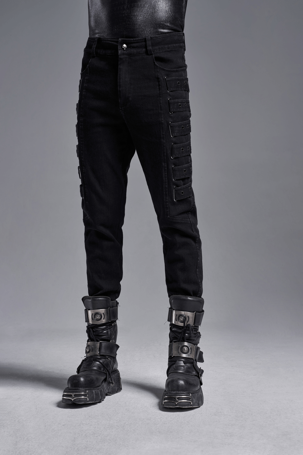 Urban black strap-detailed cargo trousers with distinctive side grommets and stylish black boots for an edgy look.