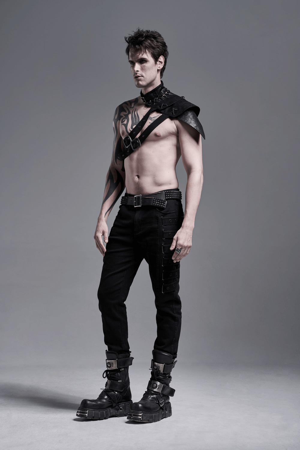 Model showcasing urban black strap-detailed cargo trousers with edgy accessories and boots.