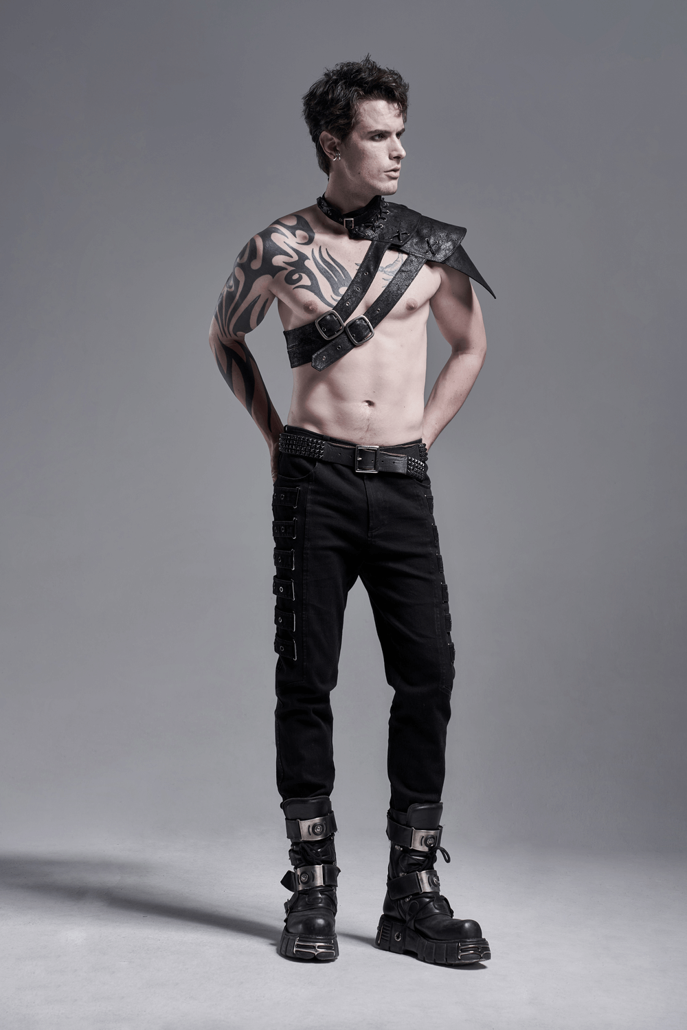 Stylish male model wearing urban black cargo trousers with a unique strap detail and statement accessories.