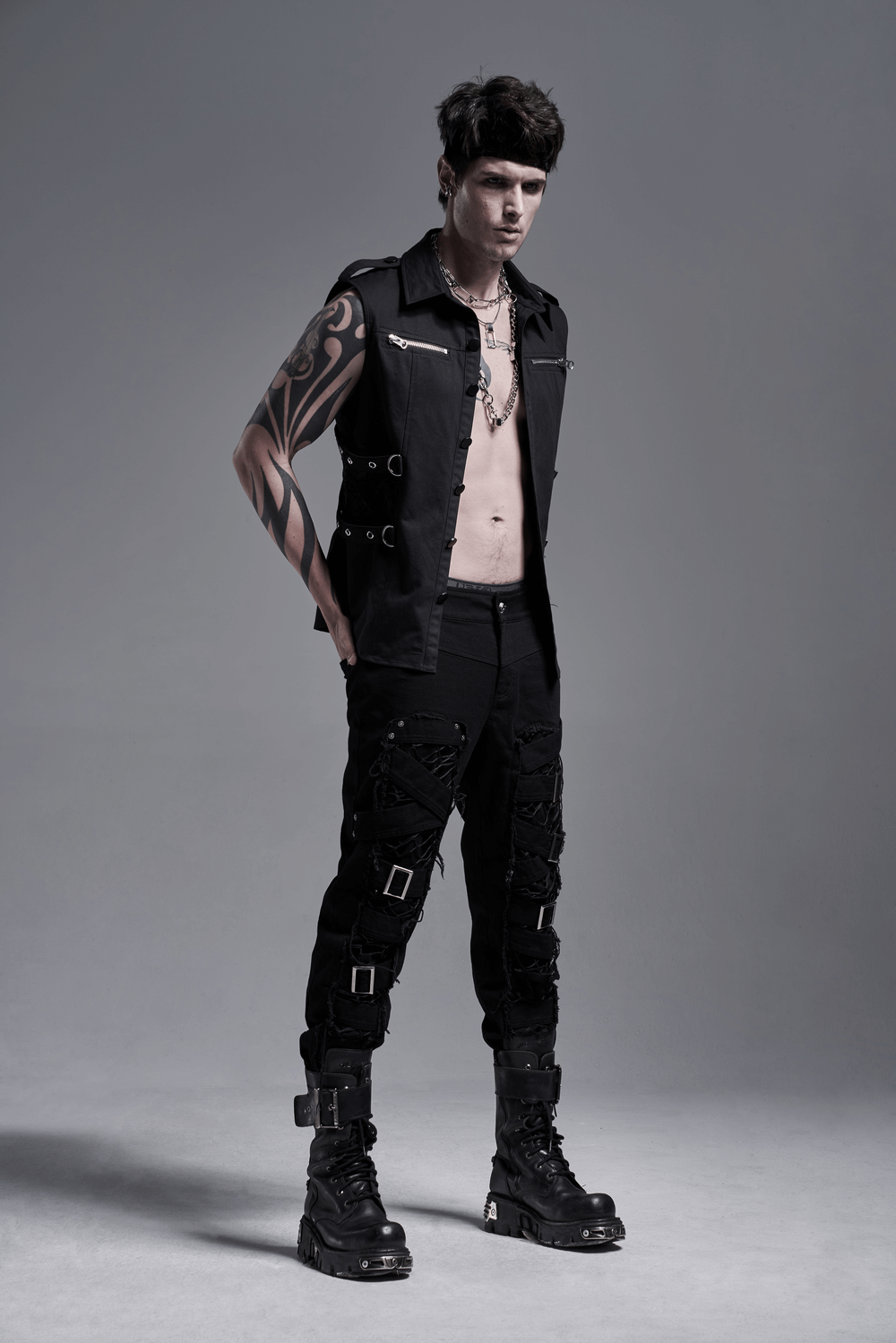 Model wearing Urban Gothic Buckled Strap Cargo Pants with punk style sleeveless shirt, showcasing edgy fashion.