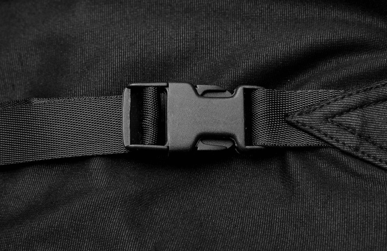 Close-up of a black nylon strap buckle, showcasing a sturdy and reliable fastening mechanism.