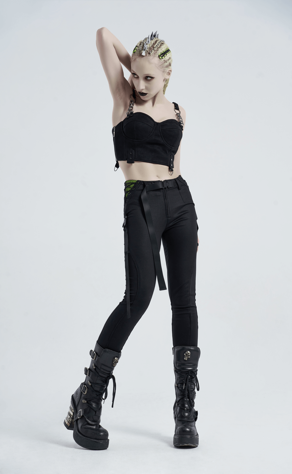 Urban punk model in black zippered leggings with bandage accents, styled with a trendy black crop top and edgy boots.