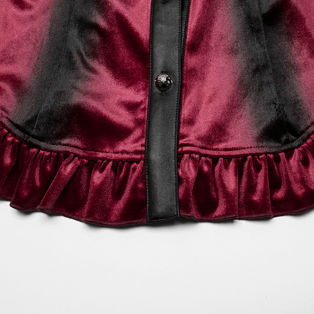 Close-up of velvet batwing collar shirt with ruffle hem and carved button detail in gothic gradient design.