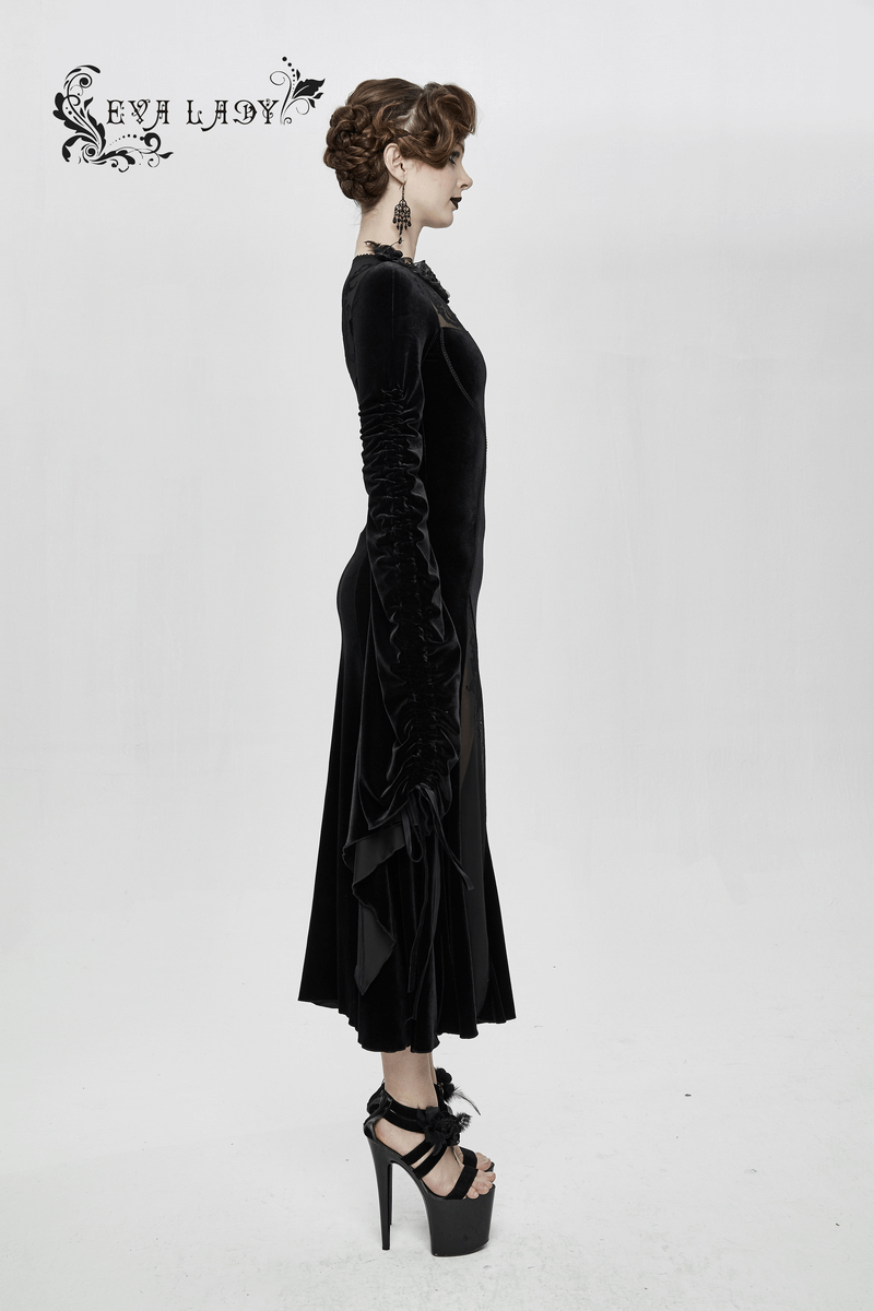 Elegant woman in a gothic velvet black dress with filigree patterns and adjustable sleeves, showcasing a graceful silhouette.