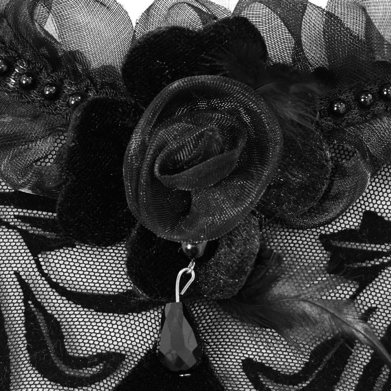 Close-up of black flower detail on a gothic velvet dress, featuring lace, beads, and elegant design elements.