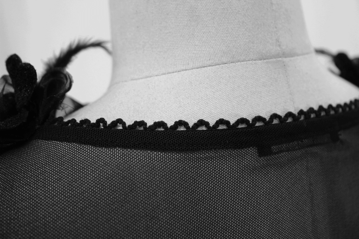 Close-up of the back neckline of a Gothic women's dress showcasing elegant black lace trim details.