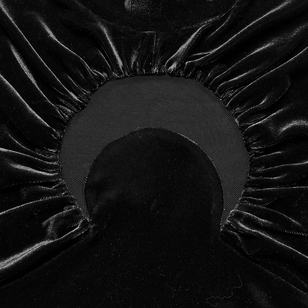 Close-up of the crescent cut-out detail on a black velvet top with gathered fabric.