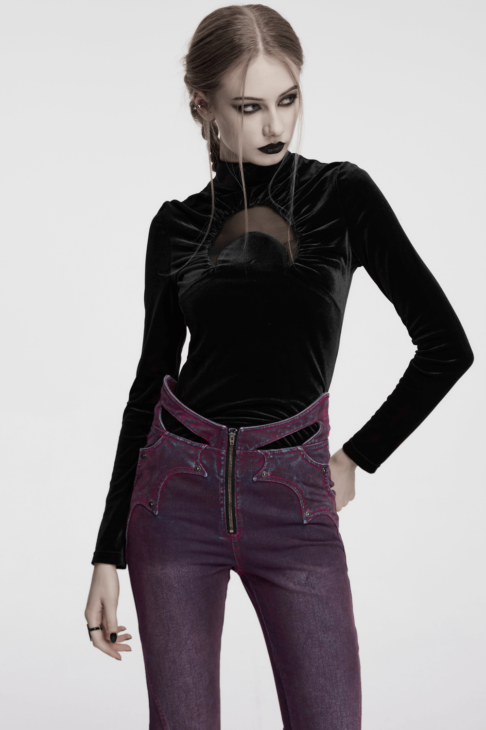 Model wearing a black velvet crescent hollowed top with a stand-up collar and stylish purple jeans.