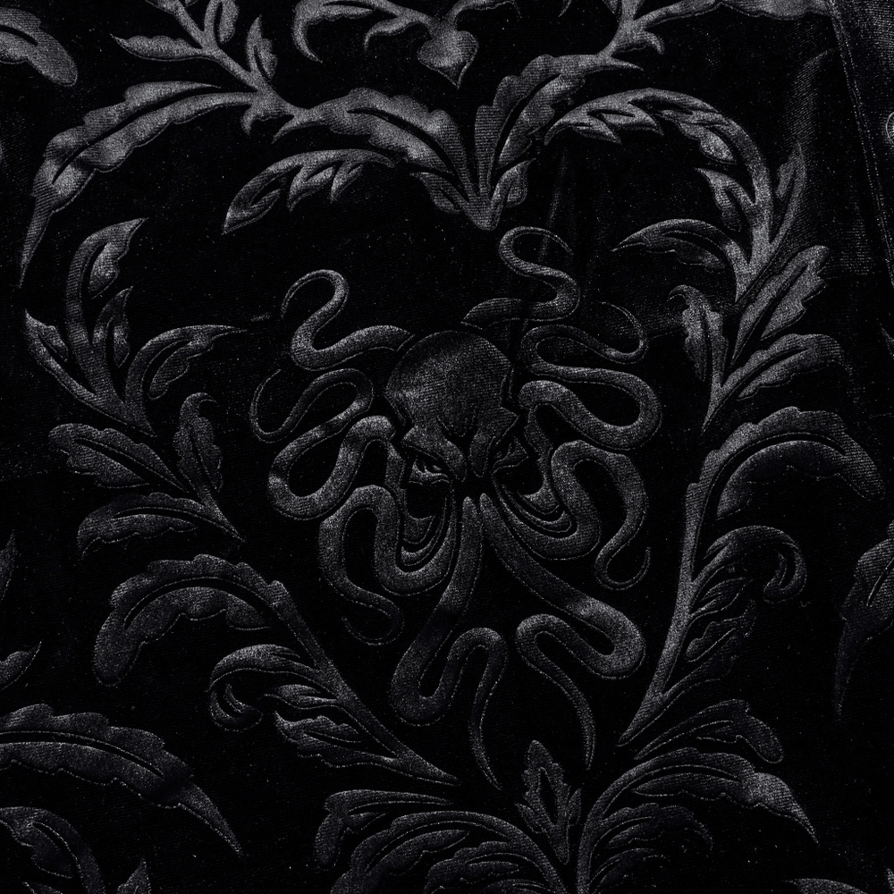 Close-up of gothic octopus embossed velvet fabric featuring intricate black floral patterns.