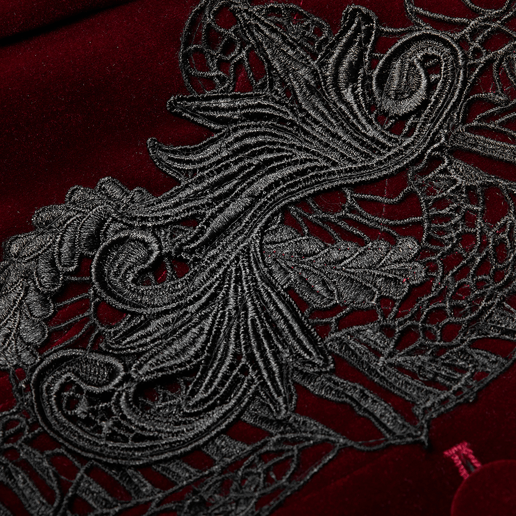 Close-up of intricate black lace detail on luxurious red velvet fabric, showcasing gothic elegance.