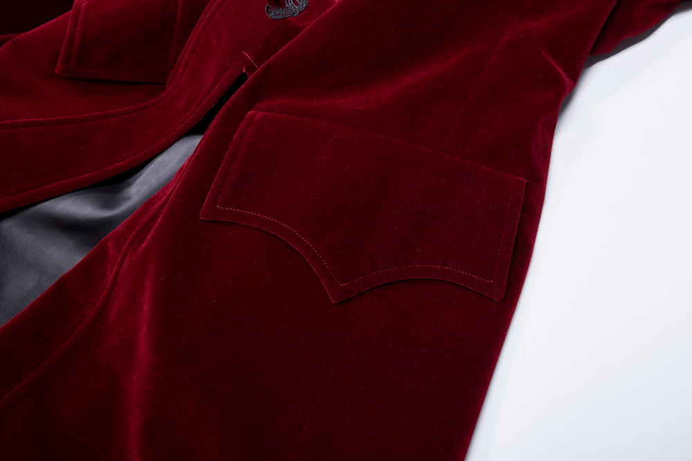 Close-up of the rich burgundy velvet fabric and pocket of a gothic mid-length coat with lace details.